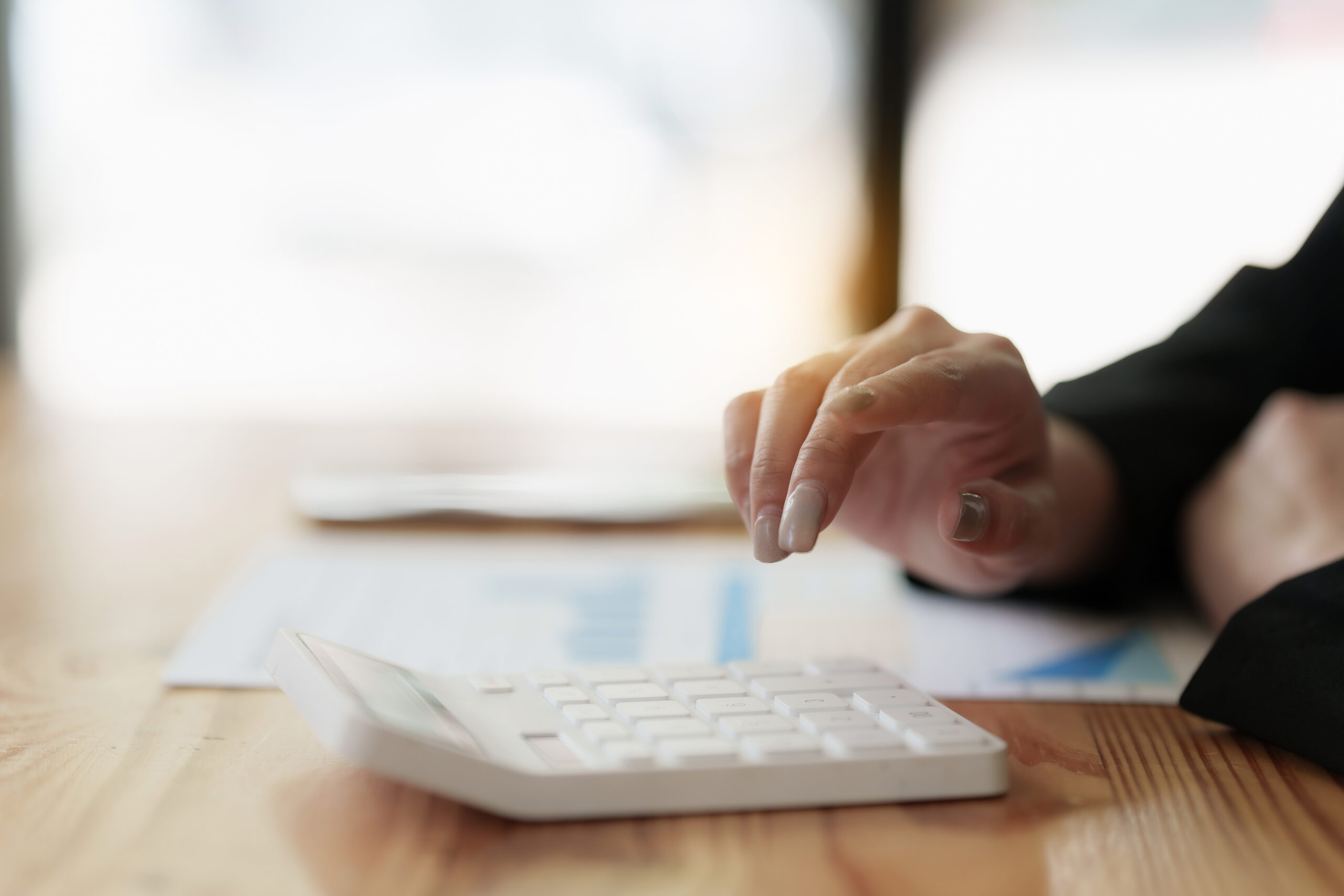 Asian Business Woman or Accountant do math and analyze with calculator and paperwork on desk, account, audit and saving concept.